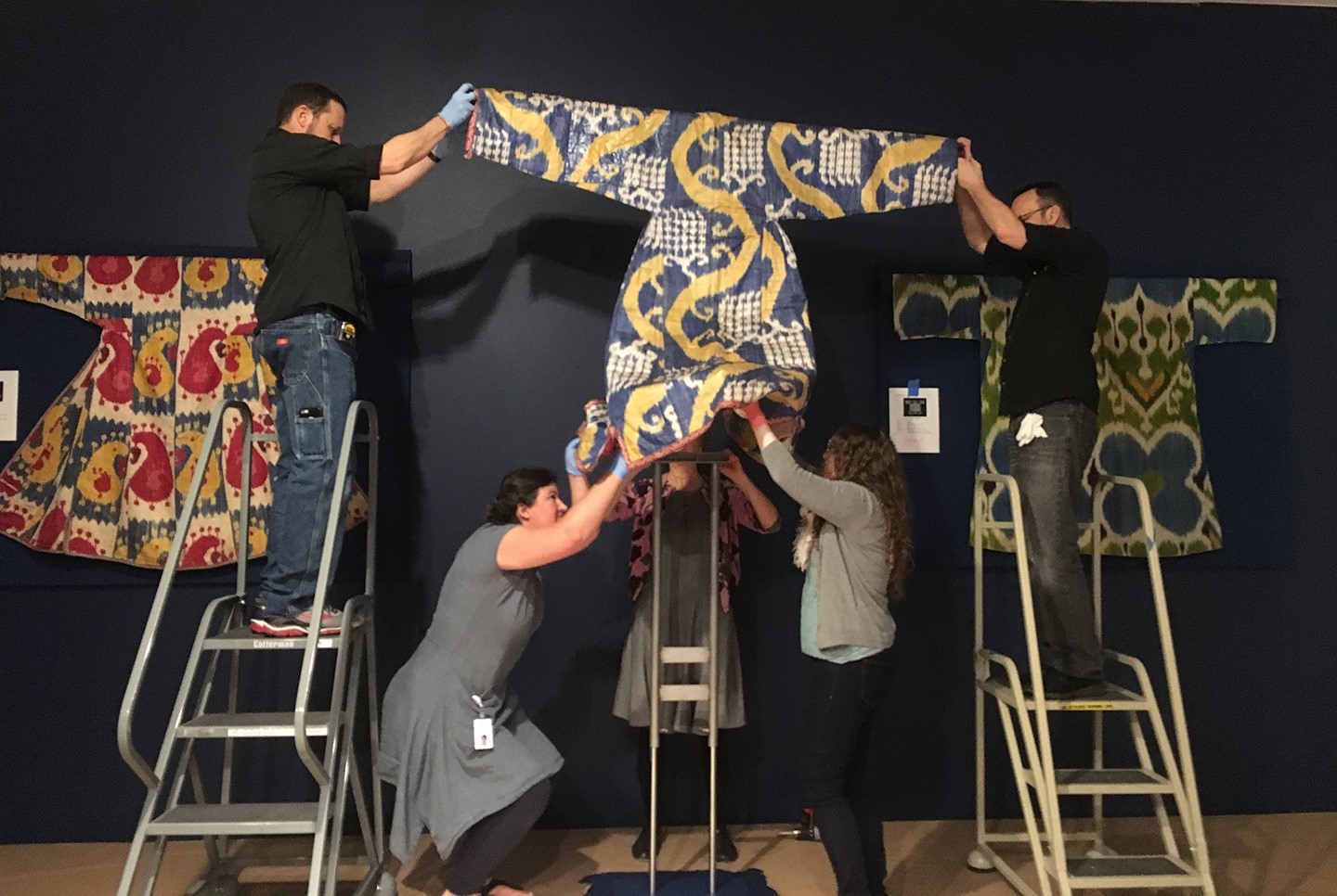 Esther Méthé (back, center) works with MFAH staff to place a woman’s robe onto a mount.
