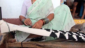 A woman binds yarn in order to create an ikat textile.