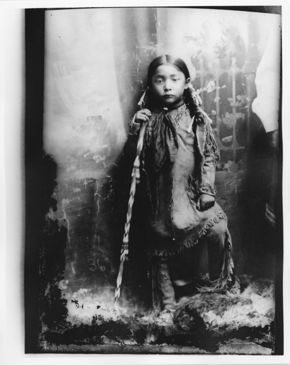Comanche Child in Buckskin Dress, Holding a Beaded Cane, c. 1895–1908, print reproduced from glass-plate negative